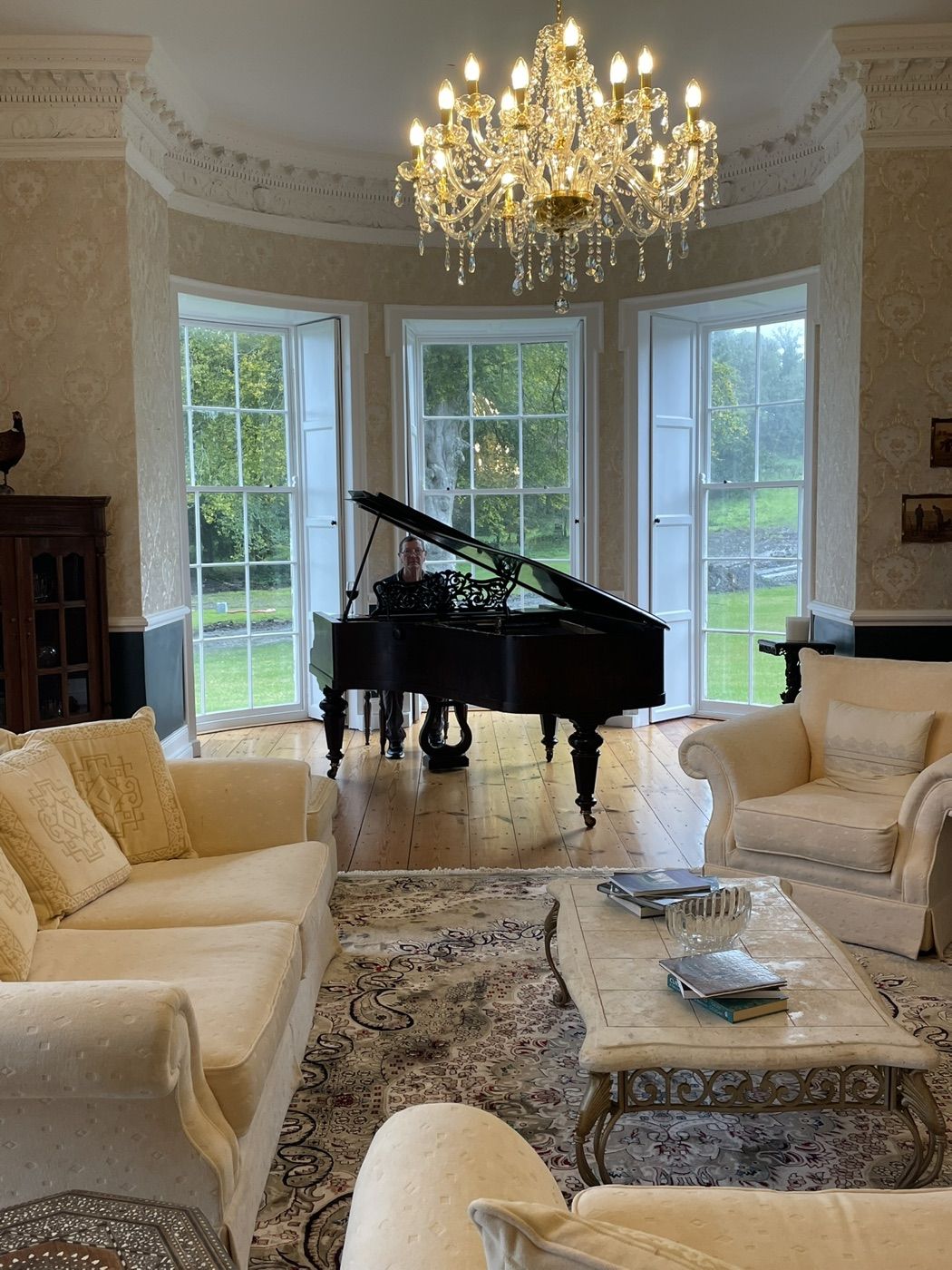 The drawing room at Newhall with a grand piano in the bow window