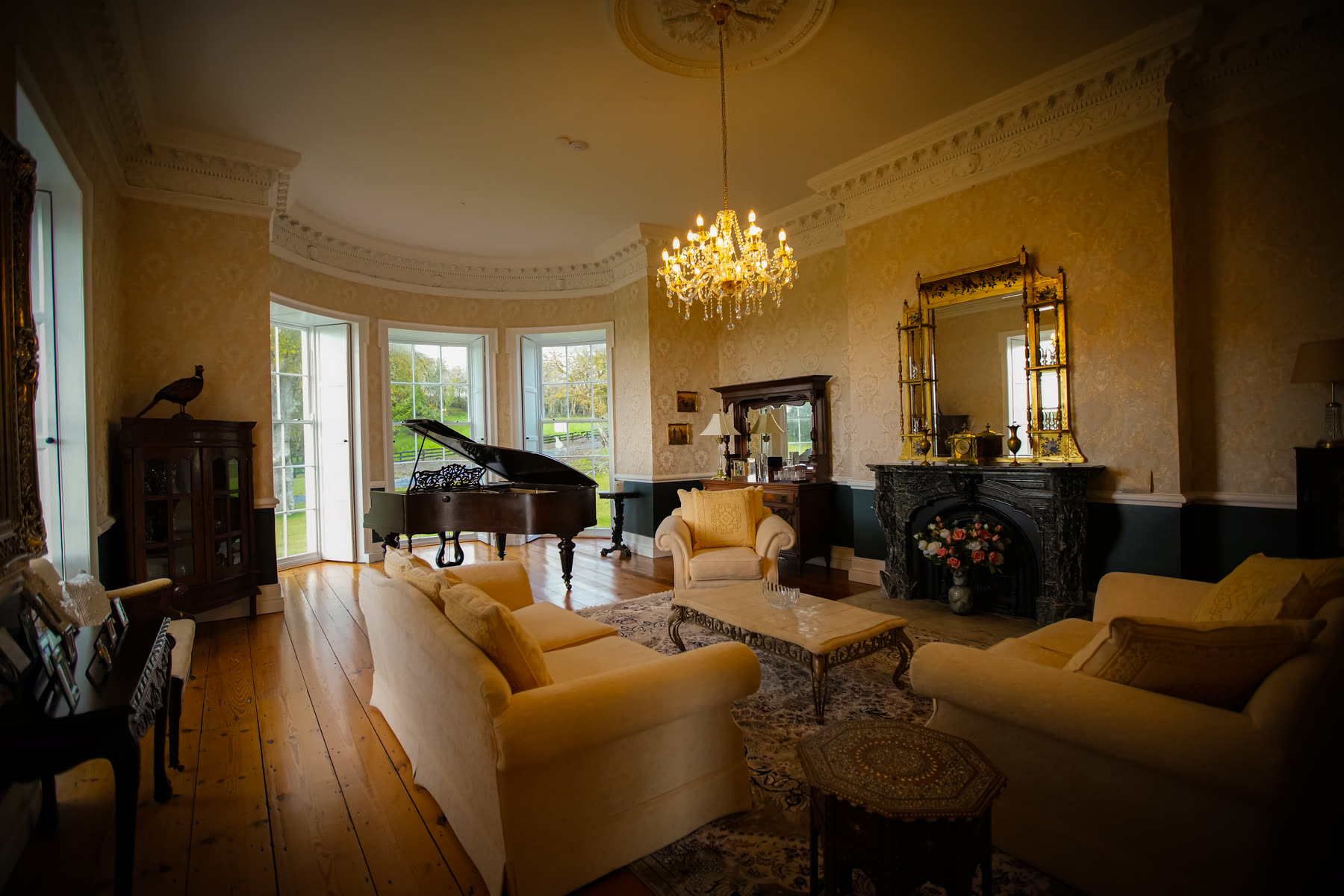 The drawing room at Newhall with a grand piano in the bow window
