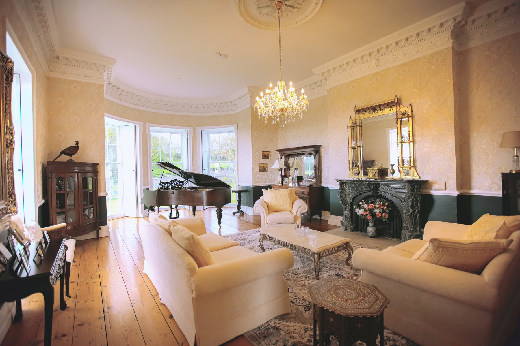 The drawing room at Newhall with a grand piano in the bow window
